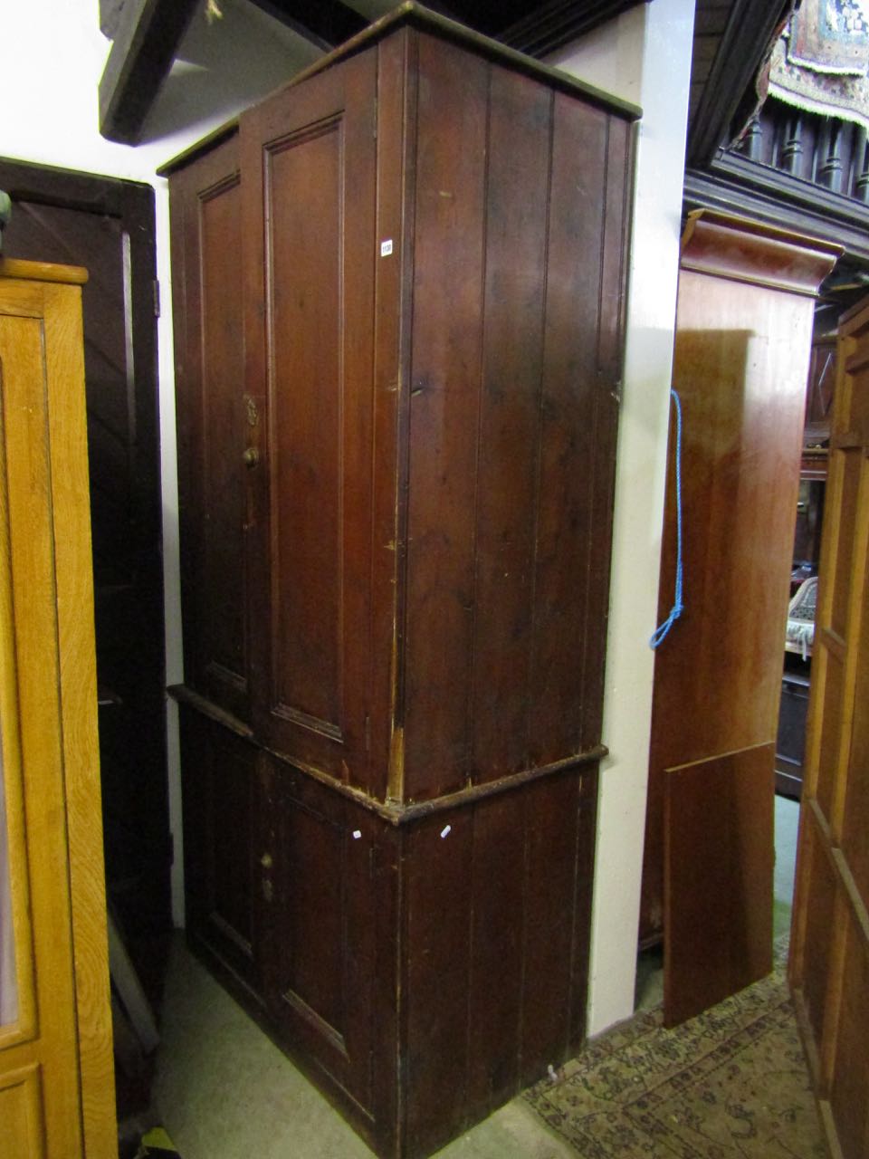 A substantial Victorian pine two tier food or linen cupboard enclosed by two pairs of panelled