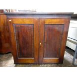 A Regency mahogany side cupboard enclosing two shelves enclosed by two panelled doors with ebony