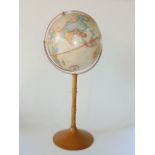 A Replogle 16 inch world classic series globe upon a turned wooden column and flared circular