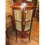 A freestanding inlaid Edwardian mahogany bow fronted corner cupboard, the upper section enclosed