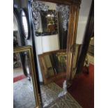 A rectangular overmantle mirror in a Deco style with applied and silvered corner mounts, 165 cm x 57