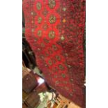 An Afghan red ground wool runner with multi medallion centre within running borders, 260x80cm