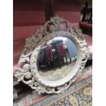 A circular convex mirror, the carved and pierced framework with scrolled acanthus and other