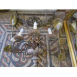 A carved wooden and scrolled metal three branch wall light together with a pair of lights with