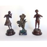 An Art Nouveau cast spelter figure of a beauty, her face coming from a flower together with two cast