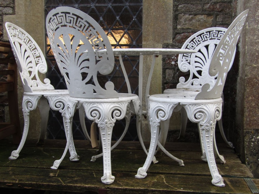 A cast aluminium garden terrace set comprising circular table and four fan backed chairs with