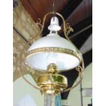 An early 20th century Belgian hanging ceiling light with brass frame, opaque white glass shade and