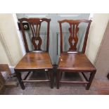 A pair of mid 18th century country made dining chairs in oak with pierced vase shaped splats,