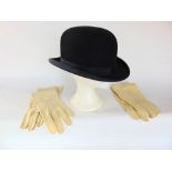 A silk lined bowler hat together with two pairs of kid leather gloves.