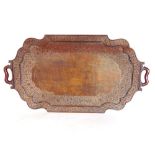 A carved eastern hardwood twin handled gallery tray with serpentine type frame, carved with scrolled