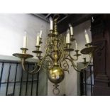 A substantial three tier brass chandelier in the Dutch manner with fourteen scrolling branches
