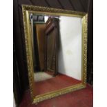 A rectangular gilt framed overmantle mirror with bevelled edge plate with geometric moulded frame,