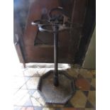 A Victorian cast iron stick stand with octagonal drip tray, central collar and four ring support