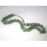 A hard stone bead necklace, possibly jade, with later applied gold chain and clasp, 115g