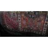 Two small eastern rugs, both with red ground fields and geometric panels within running borders,