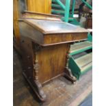 A Victorian figured walnut davenport of usual form with four real and four dummy drawers raised on