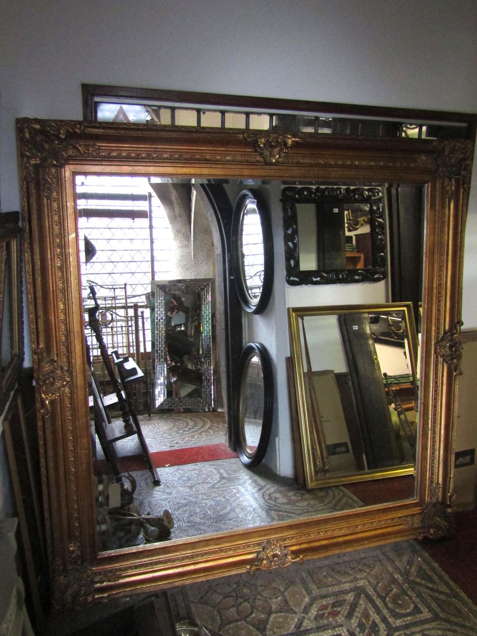 A substantial 19th century style wall mirror of square cut form with bevelled edge mirror plate, the