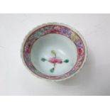 An oriental tea bowl with shaped rim and famille rose painted floral decoration to the interior