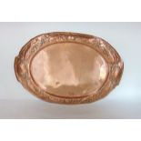 A Newlyn Arts & Crafts copper tray of oval form, the rim embossed with fish and shells, 52 cm long