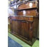 A mid Victorian mahogany chiffonier, enclosed by a pair of panelled doors, serpentine shaped cushion