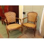 A pair of 18th century style French open armchairs with carved and painted show wood frames, cane