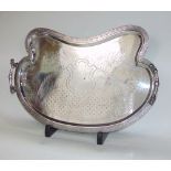 An impressive twin handled kidney shaped gallery tray, engraved with a rococo type pattern, the