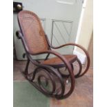 An early 20th century bentwood child's rocking chair with cane panelled seat and back