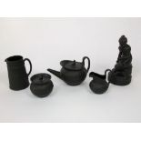 A collection of Wedgwood black basalt wares comprising an early 20th century model of Psyche, seated