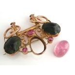 An Egyptian revival brooch in unmarked yellow metal, set with semi-precious pink stones, two