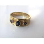 A semi-precious three stone ring in 9ct gold with textured finish, size N/O, 5g