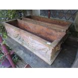 A pair of terracotta flower troughs of rectangular form with raised tied ribbon, trailing fruit