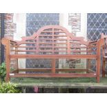 A contemporary teak three seat garden bench in the Lutyens style