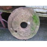 A weathered granite mill stone 48 cm in diameter approx