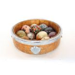 Silver plated oak barrel dish containing a collection of marble type eggs