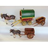 Three porcelain horses together with three treen hand modelled carts and a further gypsy wagon,