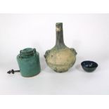 An oriental kettle type vessel with green glazed finish and moulded loop handles, cast metal spout