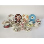 A collection of cups, saucers and trios, including examples by Royal Albert in the American Beauty