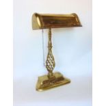 A good brass bankers light, with typical long arched shade upon an open barley twist column and base