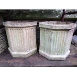 A pair of cast composition stone garden planters of octagonal form with fluted detail