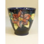 A WILLIAM MOORCROFT SIGNED CLEMATIS? DESIGN JARDINIERE/VASE ON A BLUE GROUND (H: 12.5 cm)