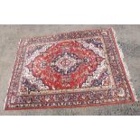 INDIAN TABRIZ PATTERN CARPET, THE MADDER FIELD WITH A CENTRAL PENDANT MEDALLION, SPANDRELS AND