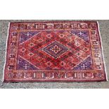 PERSIAN MADDER FIELD CARPET WITH A CENTRAL STEPPED LOZENGE MEDALLION, SPANDRELS AND ALL-OVER