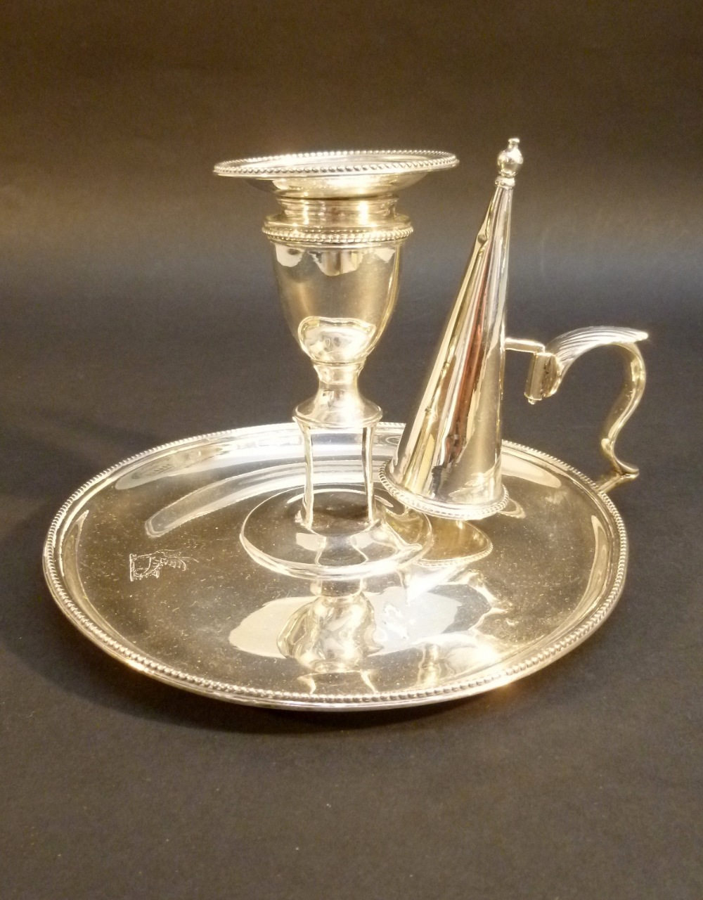 GEORGE III SILVER CHAMBERSTICK OF CIRCULAR FORM WITH FLARED BEADED RIM AND ENGRAVED DRAGON CREST, BY