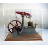 A CAST IRON SCALE MODEL OF A STUART BEAM ENGINE, PAINTED GREEN AND RED WITH A SIX SPOKE FLY WHEEL