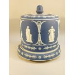 EDWARDIAN JASPERWARE CHEESE DISH AND COVER DECORATED WITH CLASSICAL FIGURES AND FLOWERS ON A BLUE