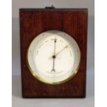 AN EDWARDIAN SHIP'S BAROMETER ENCLOSING AN ANEROID MOVEMENT IN A BRASS CASE (DIA: 12.4 cm) IN A
