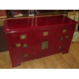 AN ORIENTAL RED LACQUERED SIDEBOARD WITH FIVE DRAWERS, TWO PANELLED DOORS WITH INSET BRASS TREFOIL