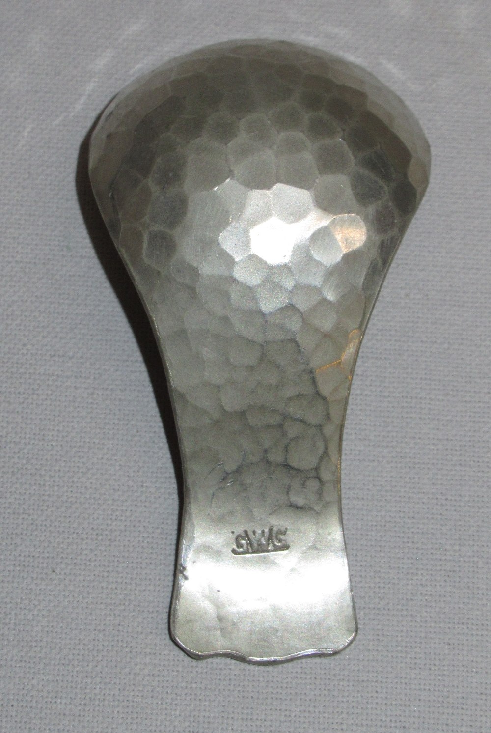 A METAL ARTS & CRAFTS HAMMERED CADDY SPOON, STAMPED ON BACK 'GWG' (L:7.2 cm) - Image 3 of 3