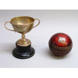 A SILVER PRESENTATION CUP ON AN EBONISED BASE TOGETHER WITH A PRESENTATION CRICKET BALL, THE