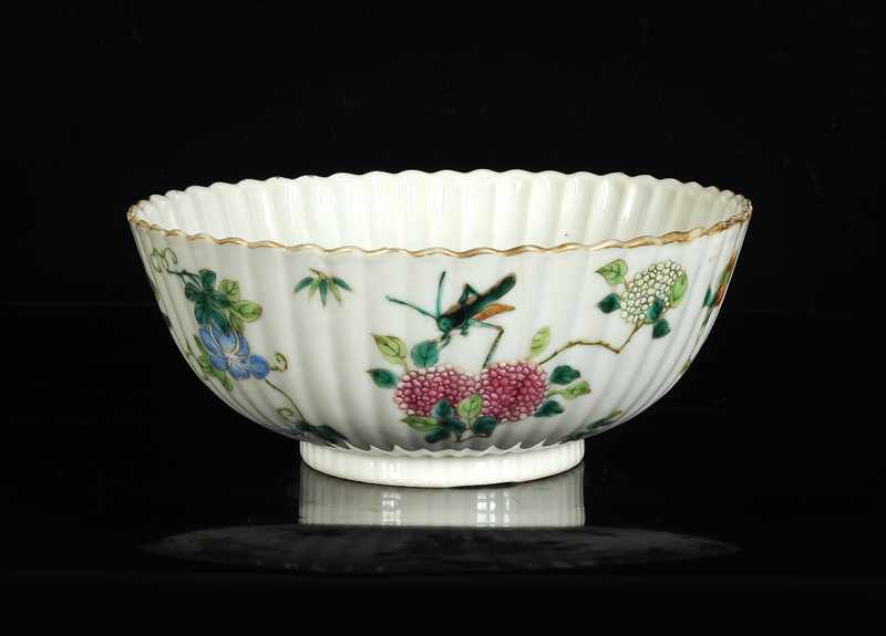 A polychrome porcelain ribbed bowl with scalloped rim and a decor of flowers and insects. Marked